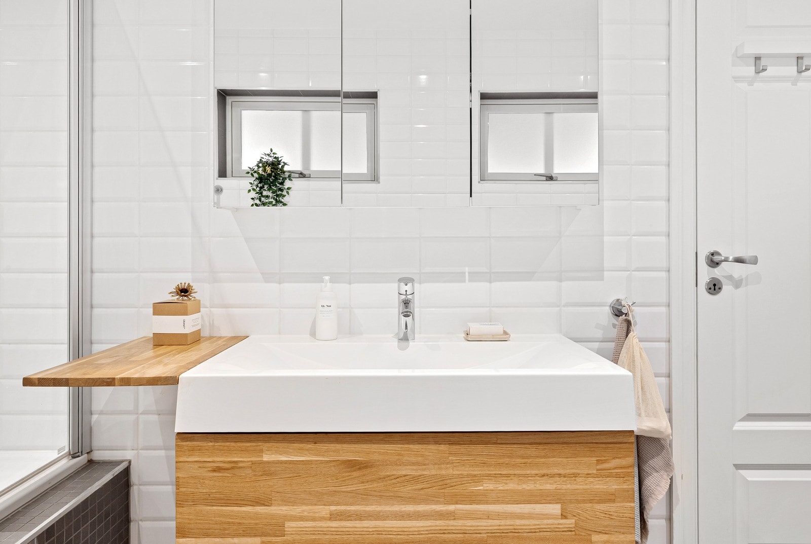 Lyst og fint helfliset bad i første etasje med slette malt himling og downlights. Galleribilde