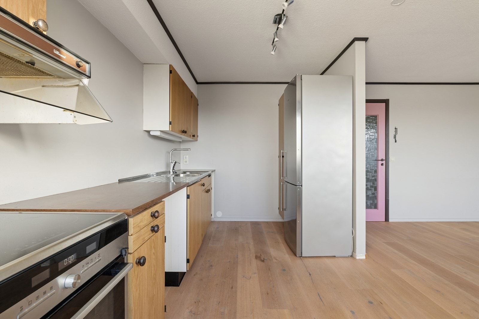 Kjøkkenet har laminerte fronter og benkeplate, samt eldre ventilator tilkoblet avtrekk. Galleribilde