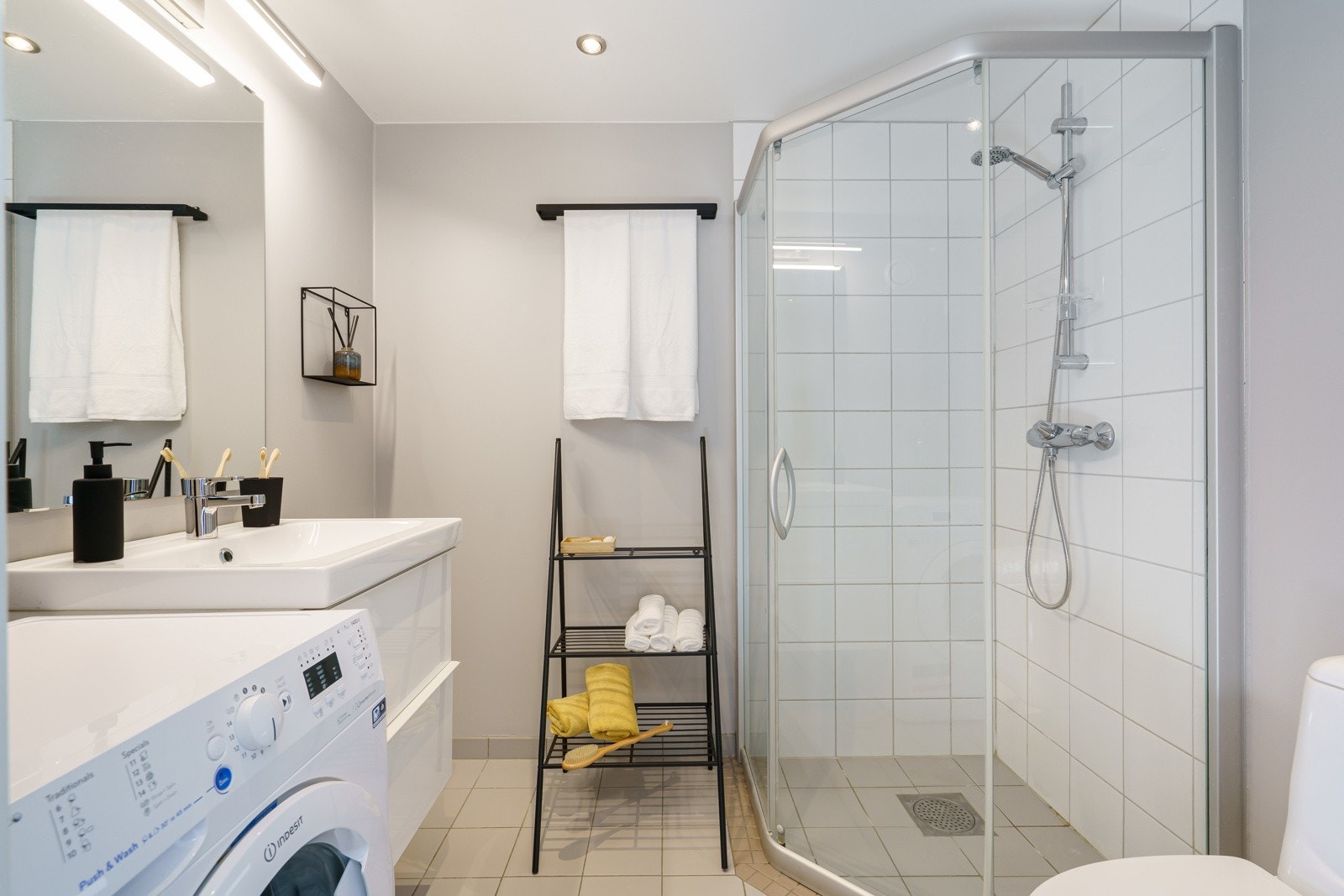 Badet er innredet med nedfelt servant, toalett, dusjhjørne og opplegg for vaskemaskin. Galleribilde