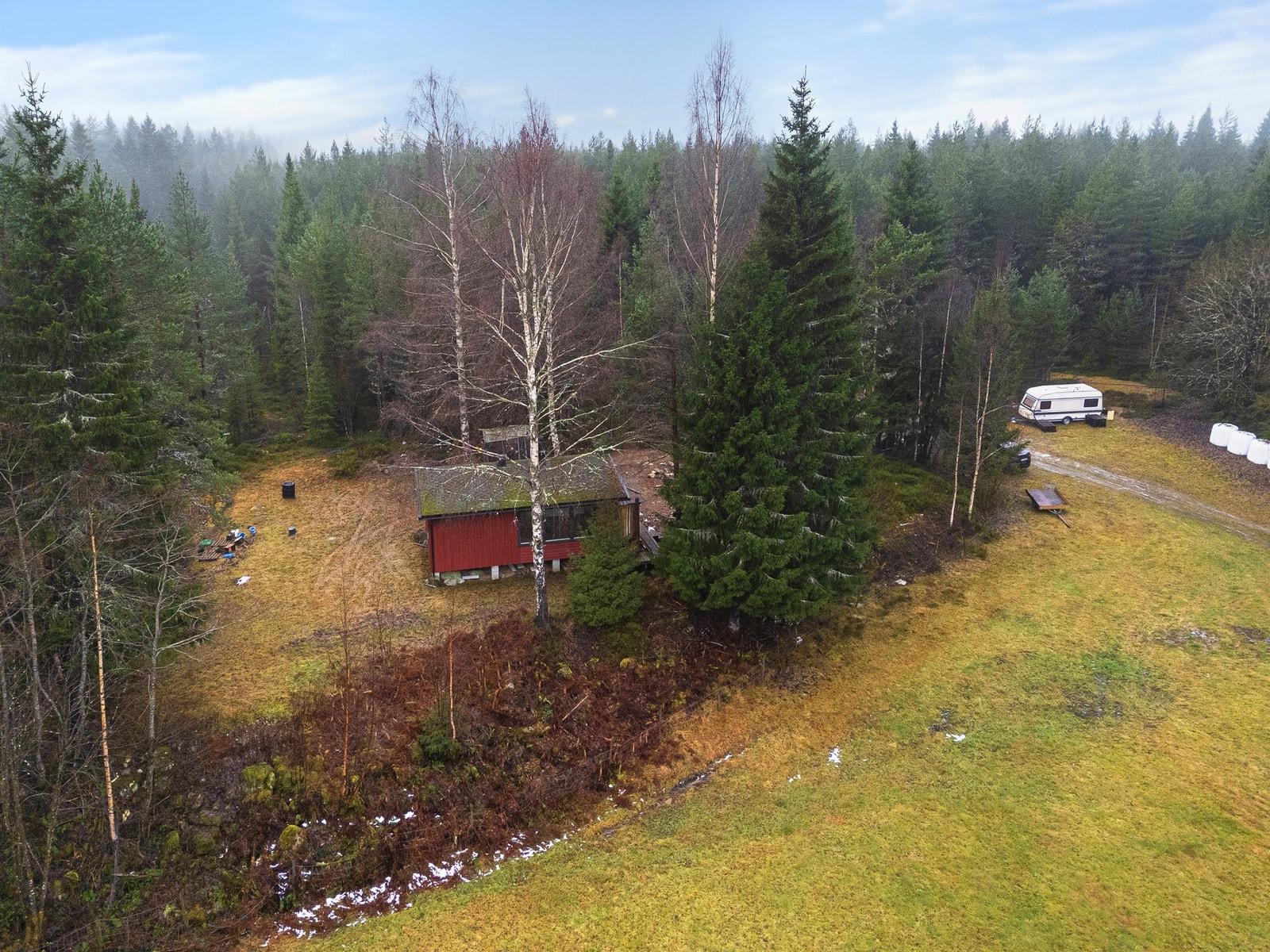Hytta med del av tomt rundt Galleribilde