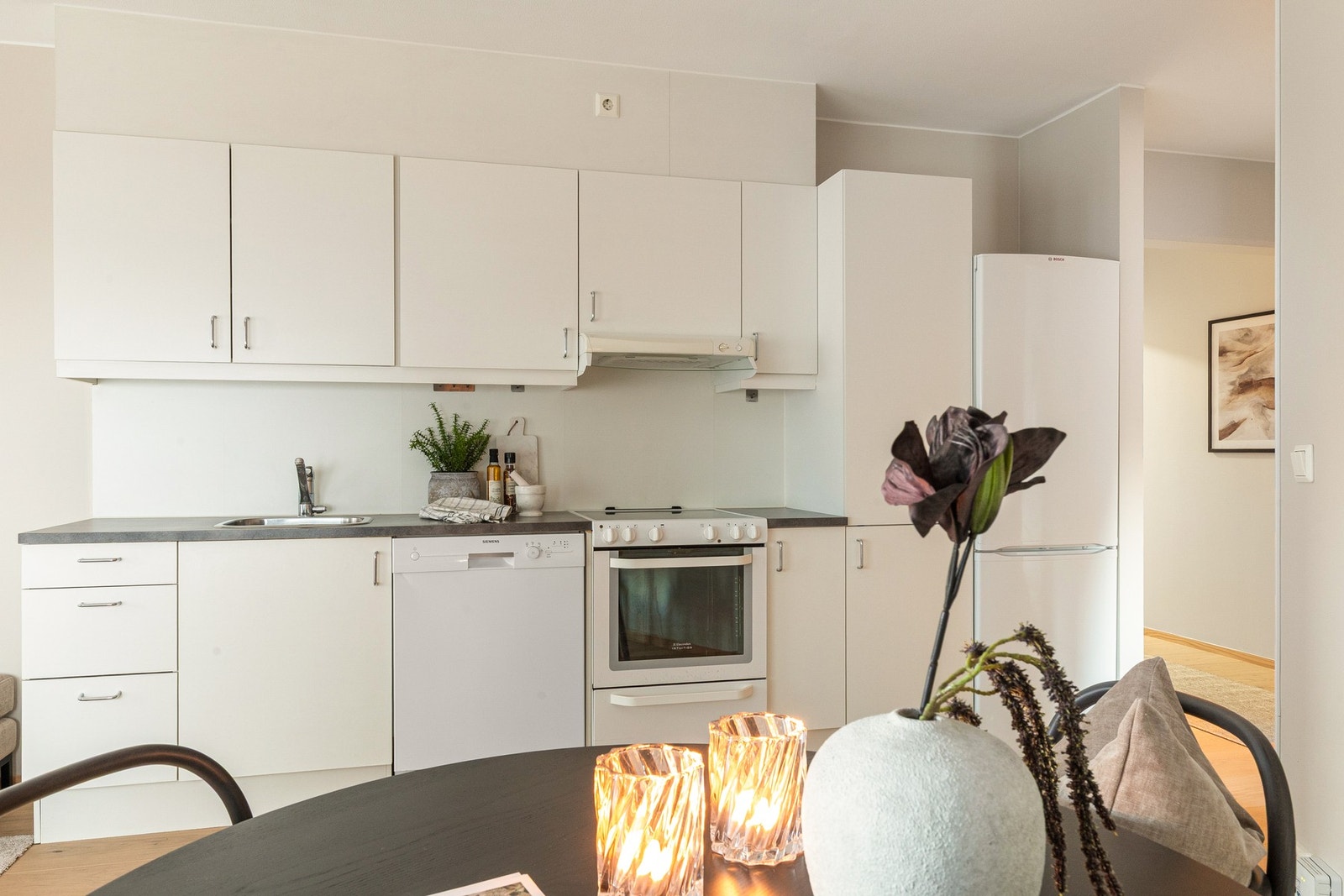 Lyst og pent kjøkken i åpen løsning med god skap- og benkeplass. Galleribilde