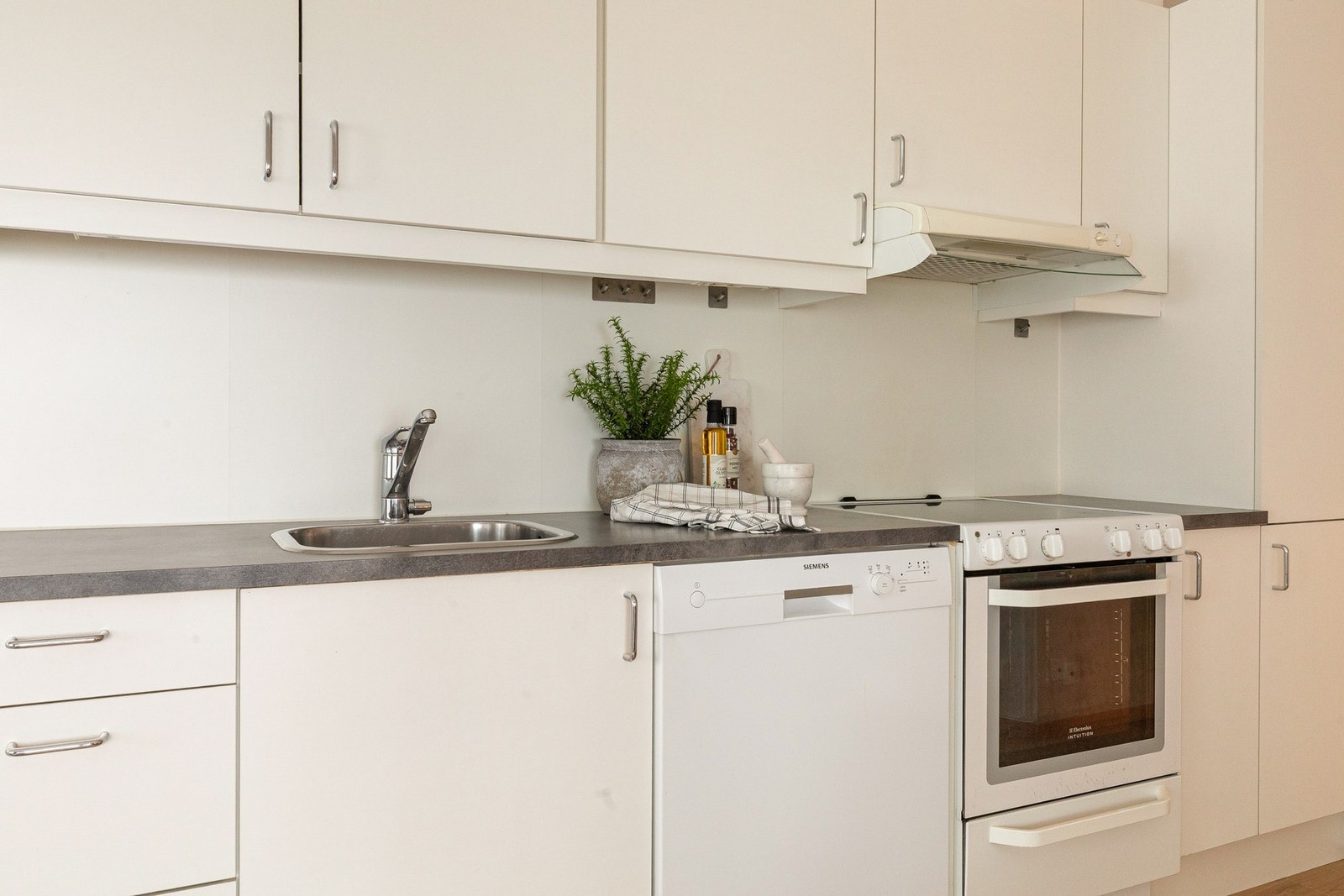 Innredning med hvite glatte fronter og laminat benkeplate. Galleribilde