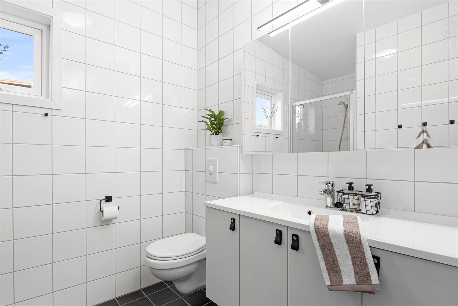 Badet har bra med oppbevaring under vask, vegghengt toalett. Galleribilde