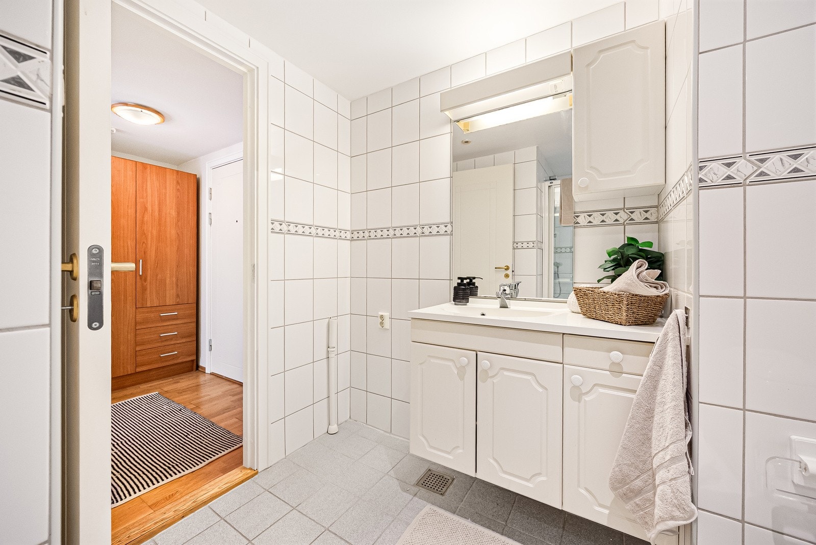 Badet inneholder dusjnisje, veggmontert servantskap og gulvstående toalett, samt opplegg for vaskemaskin Galleribilde