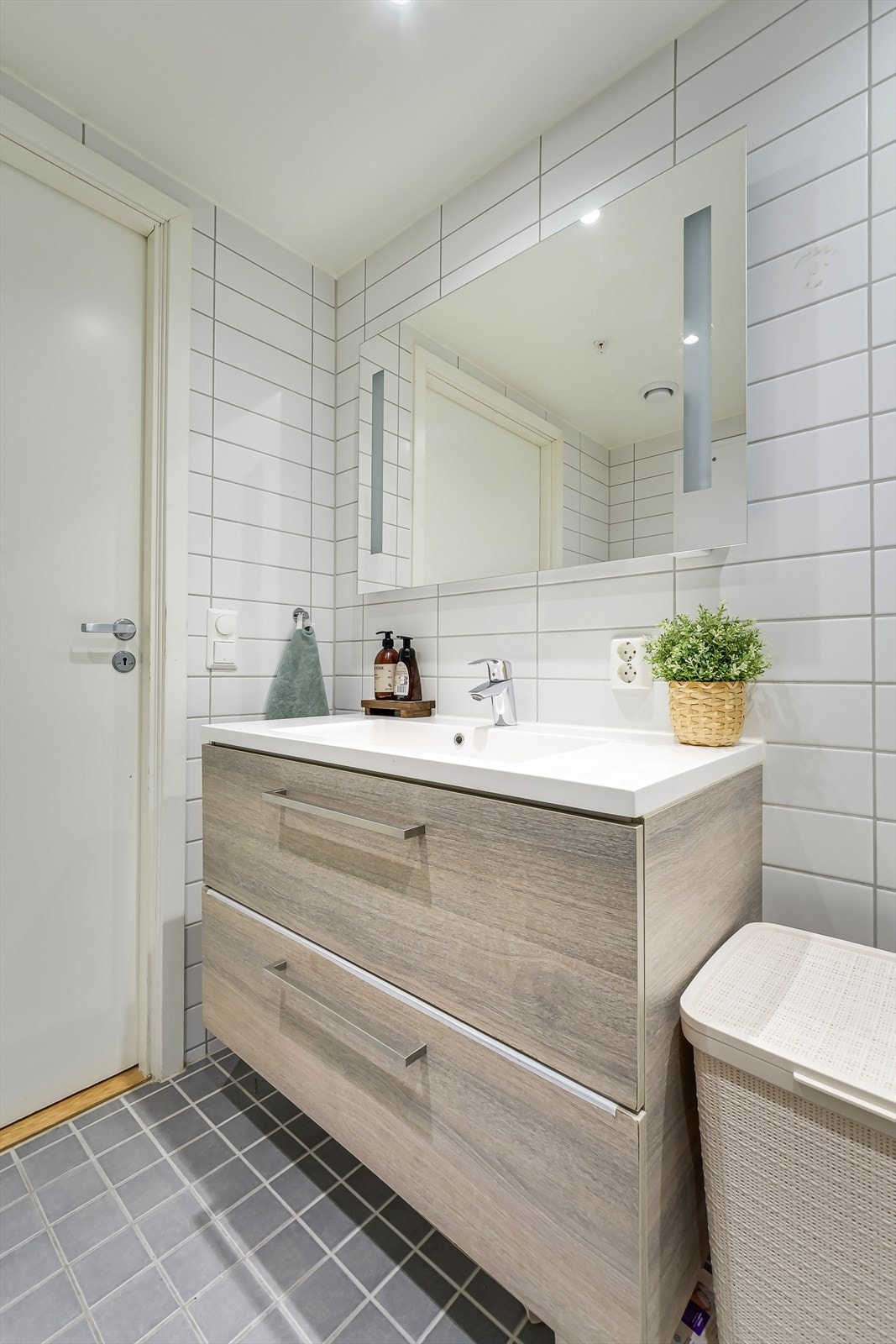 Innredningen består av servantskap, speil med lysfelt, toalett og dusj rett på flis. Galleribilde