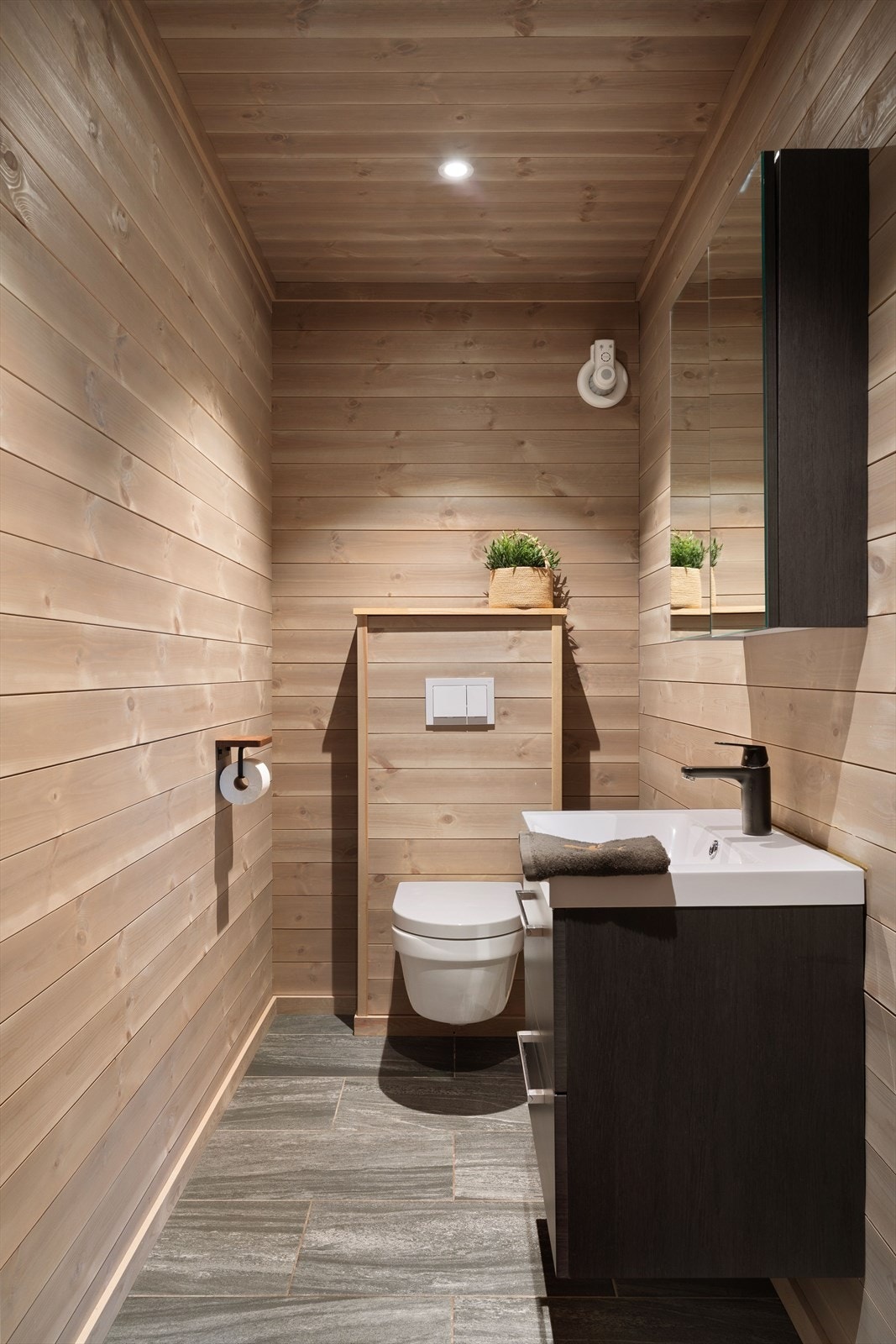 Toalettron med fliser på gulv og vegghengt toalett Galleribilde