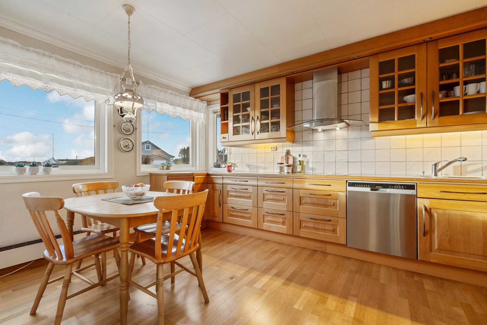 Pen og tidsriktig kjøkkeninnredning med rikelig av skap- og benkeplass. Galleribilde