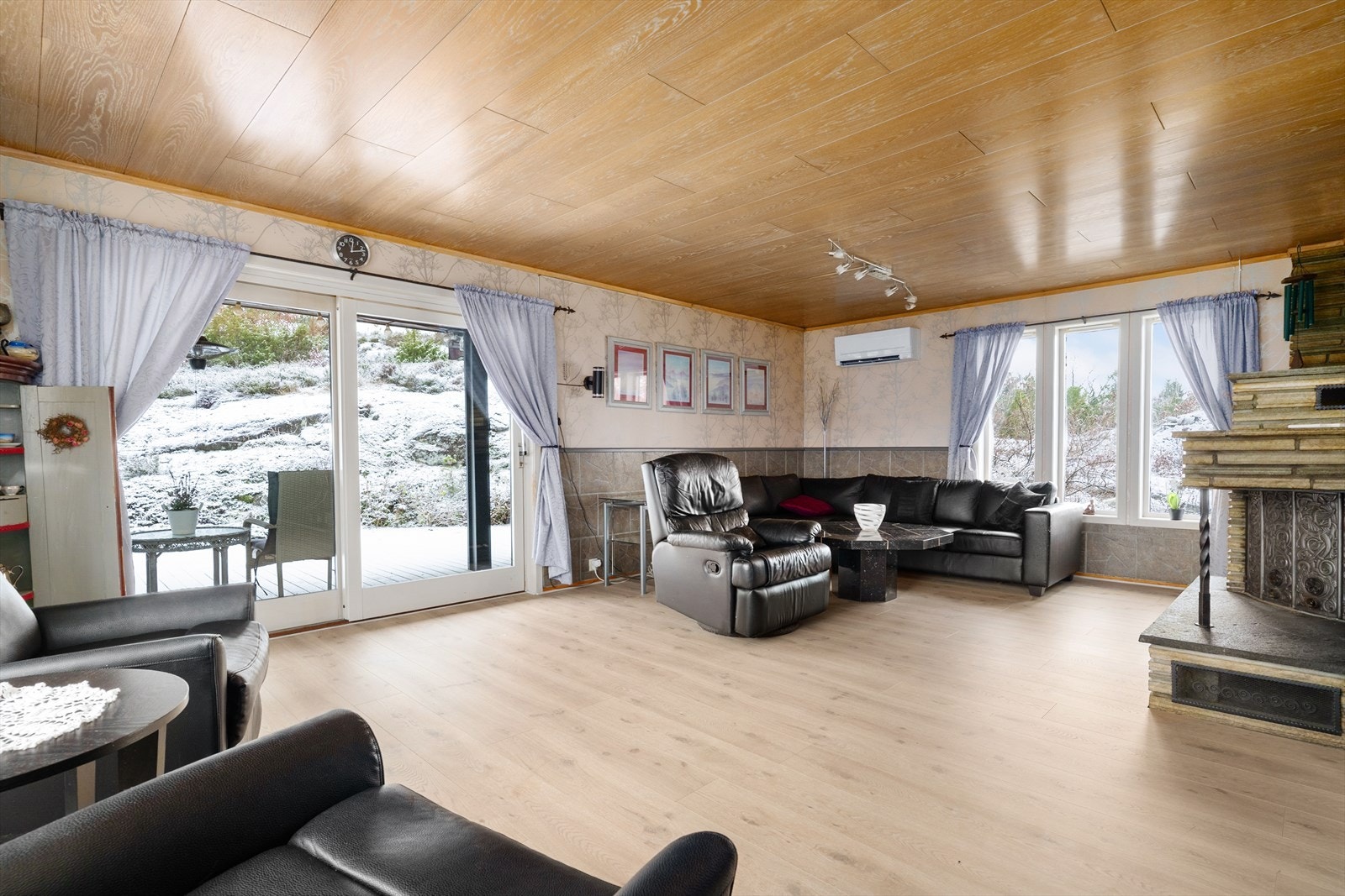 Del av stuen med utgang til terrassen. Her er det både luft til luft varmepumpe og ildsted Galleribilde