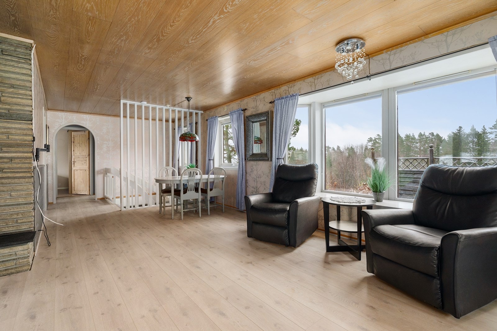 Del av stuen med store vindusflater og peis m/innsats Galleribilde