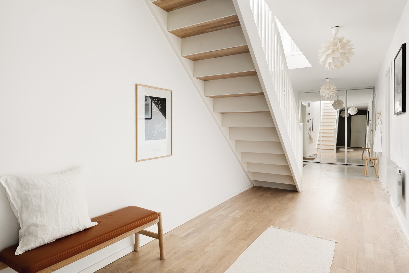 Vi beveger oss ned i hallen som måles til 20,8 kvm. Under trappen er det mulig å møblere med en koselig sofakrok, som kan brukes som stue nummer to. Galleribilde