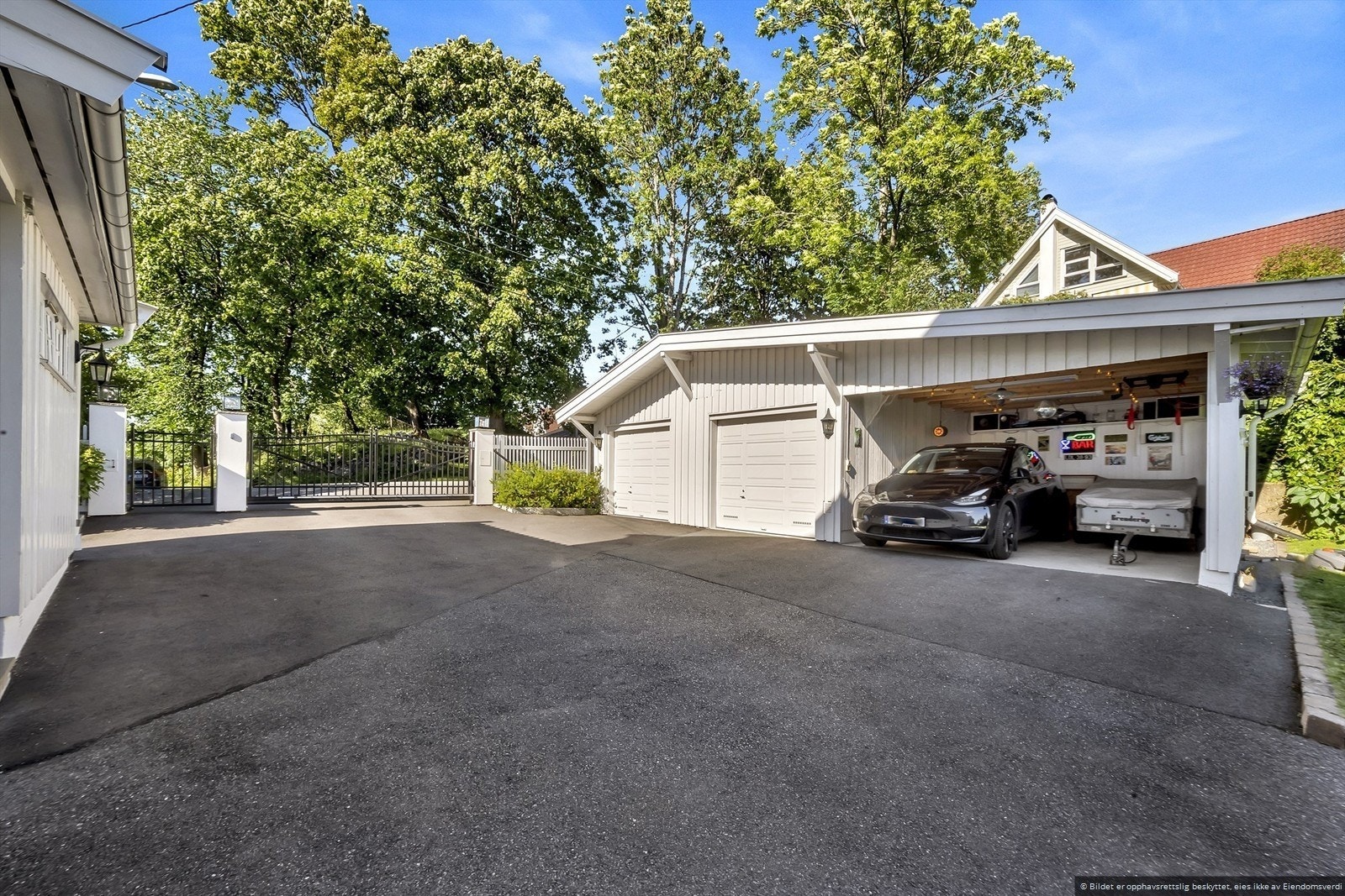 Det er plass til flere biler i garasjen og carport. Garasjen til venstre brukes til hageredskap. Galleribilde