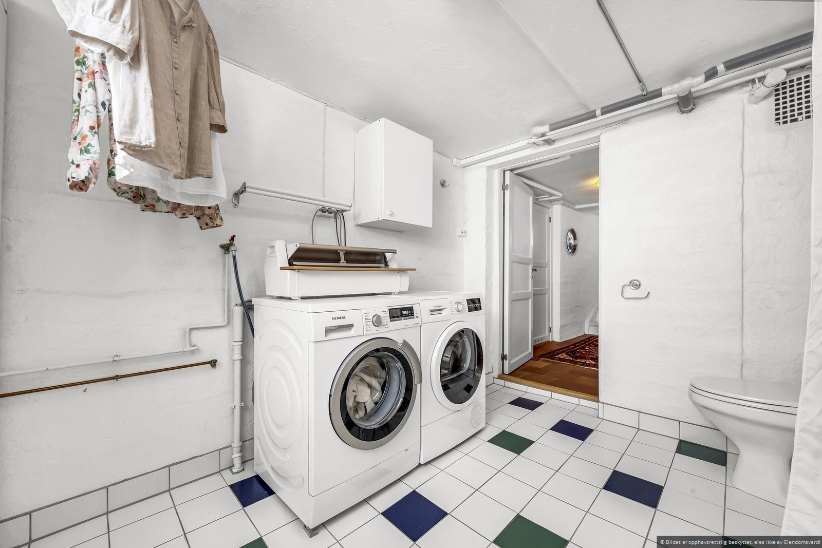 Vaskerom i kjeller med vaskemaskin og tørketrommel. Galleribilde