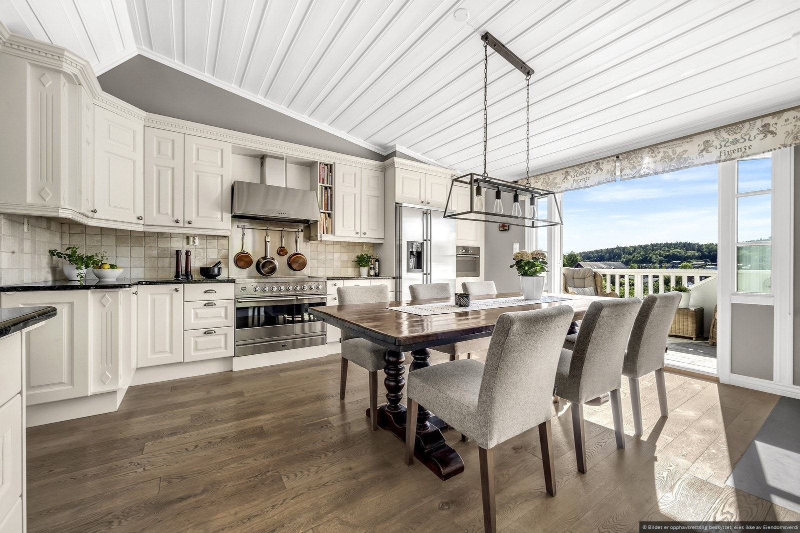 Lekkert kjøkken med integrerte hvitevarer og utgang til solrik balkong terrasse. Galleribilde