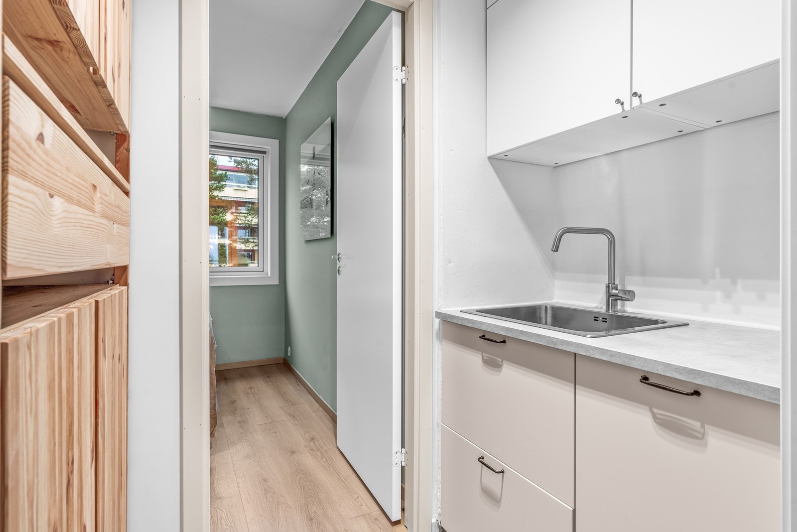 Innenfor kjøkkenet har leiligheten et lite grovkjøkken, med ytterligere oppbevaring i tillegg til integrert oppvaskmaskin og nedfelt oppvaskkum av stål. Galleribilde