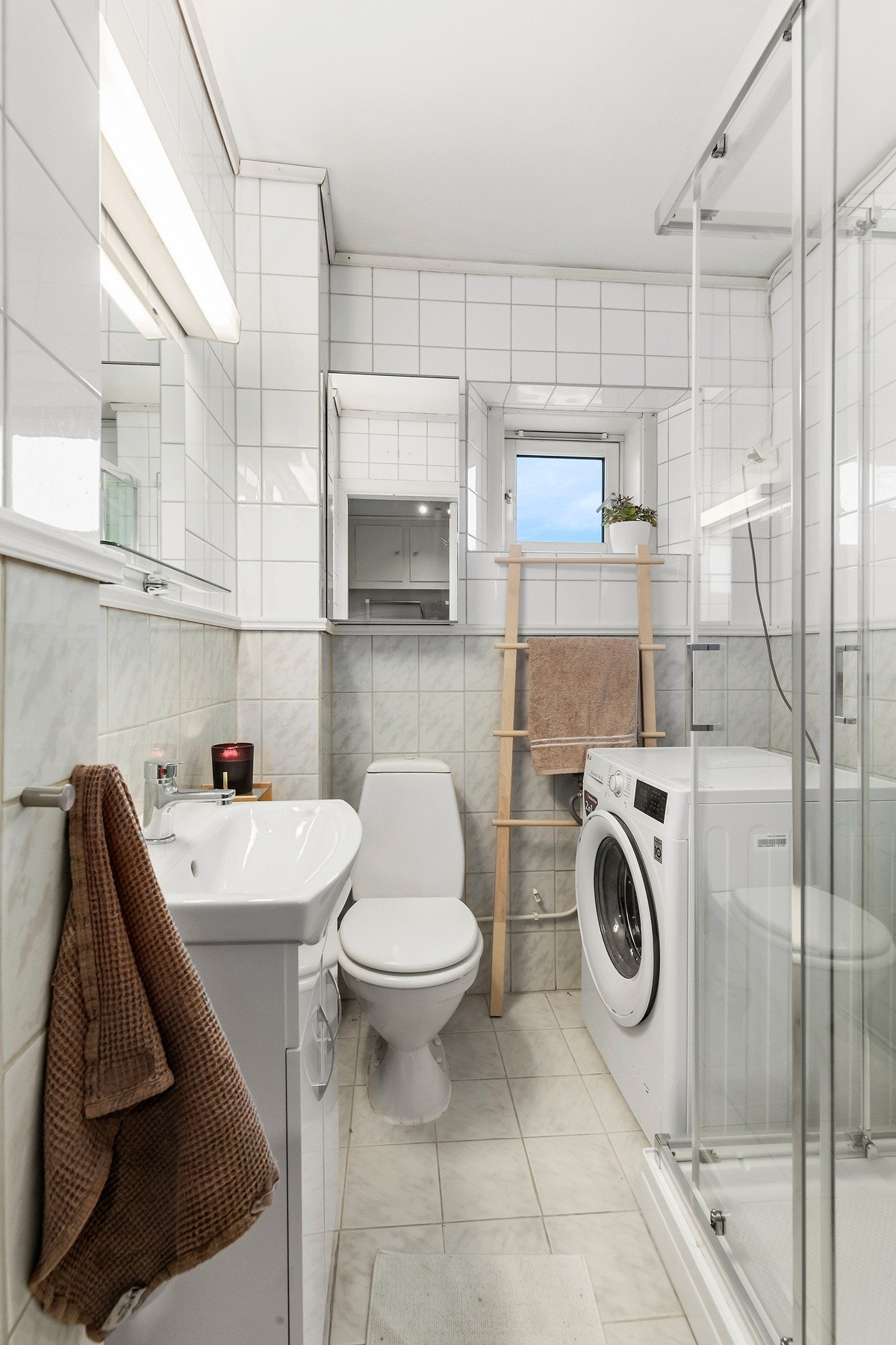 flislagt bad med dusjkabinett og opplegg til oppvaskmaskin. Galleribilde