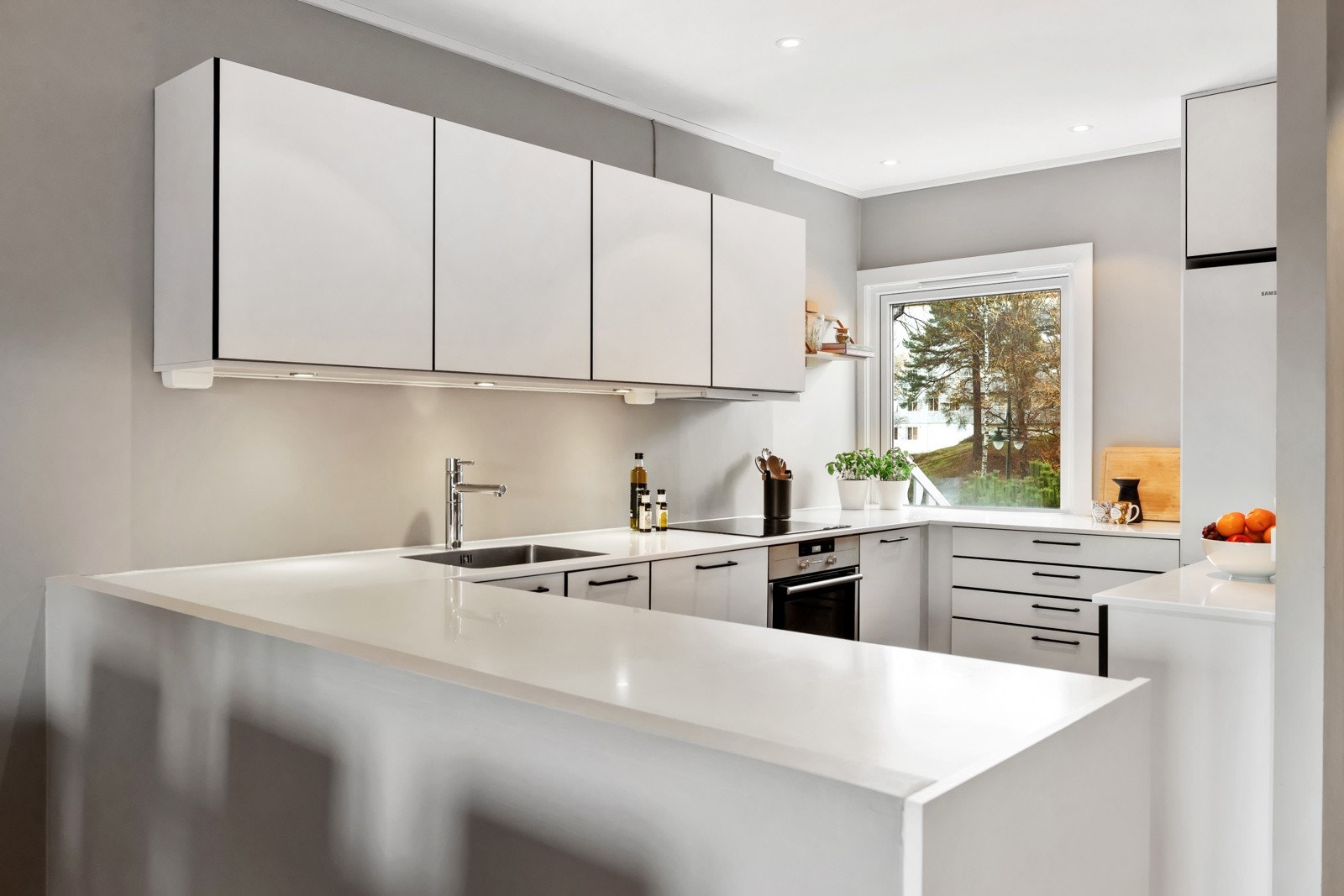 Kjøkkenet har et moderne og stilrent uttrykk med glatte, lyse fronter og gode arbeidsflater. Galleribilde