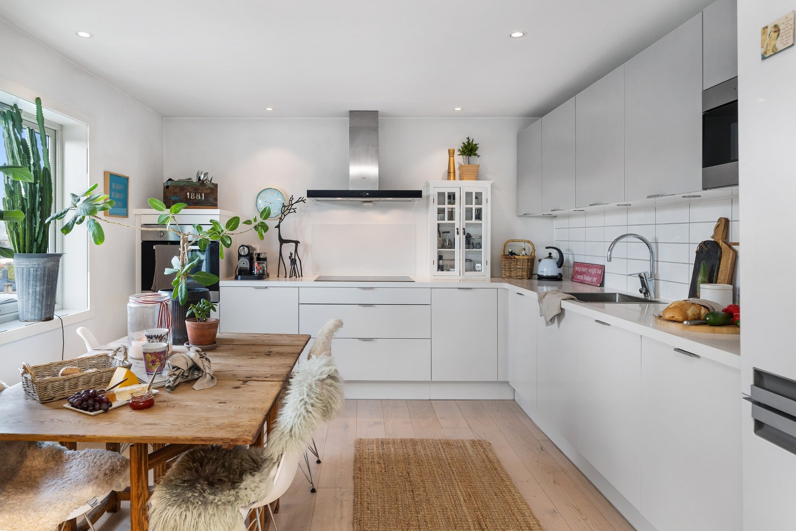 Lyst og romslig kjøkken med slette fronter og laminat benkeplate. Galleribilde