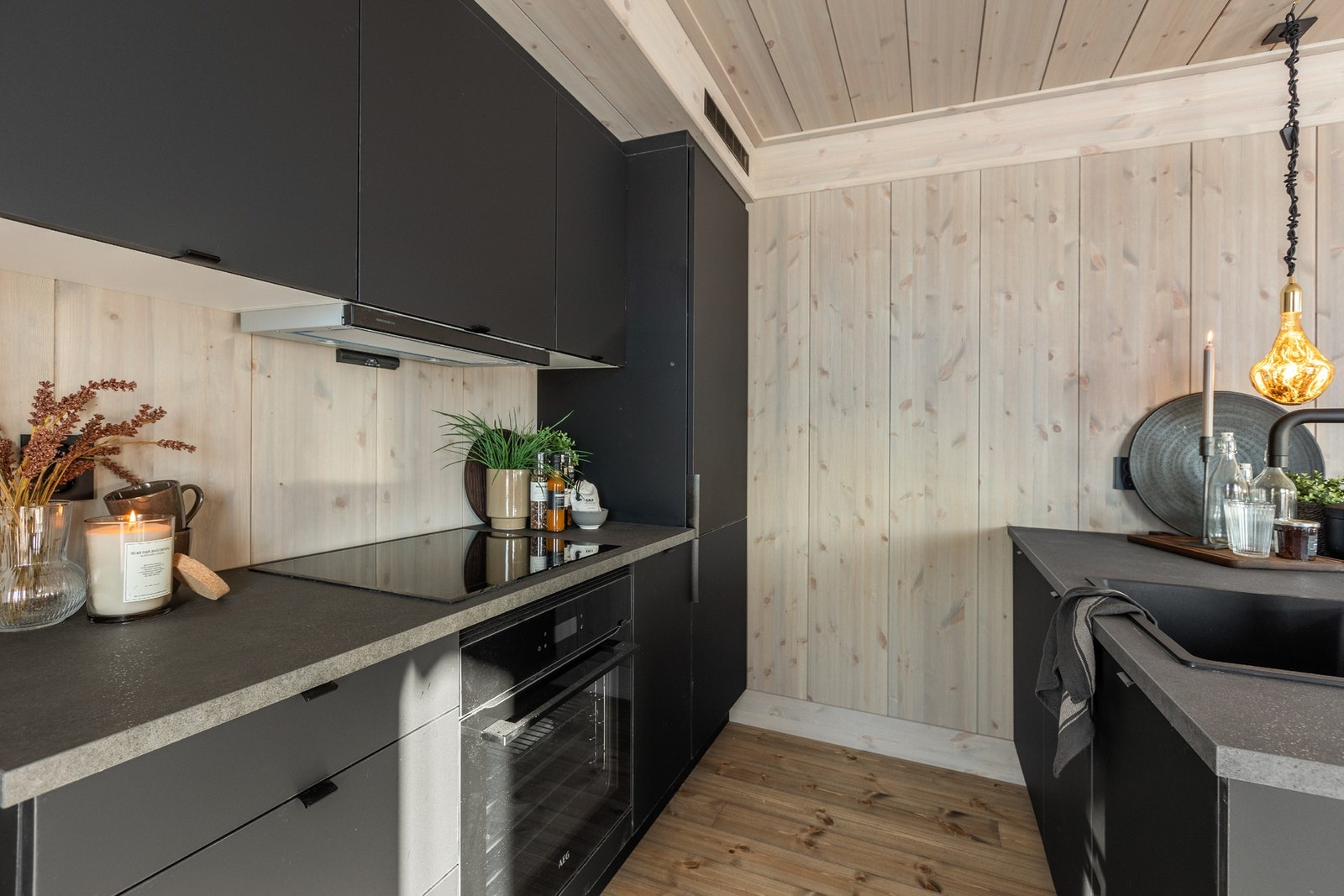 Moderne kjøkken med slette fronter og benkeplate av laminat. Kjøkkenet er fult utstyrt med integrerte hvitevarer og nedfelt komposittvask Galleribilde