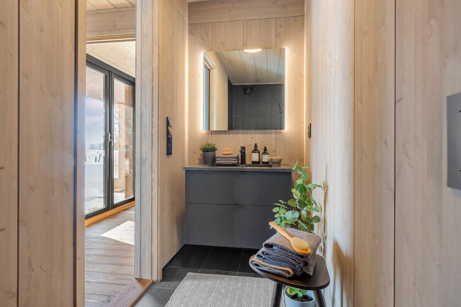 Fra hovedsoverommet får man sitt eget private bad. Badet er innredet med servantskap og speil med belysning Galleribilde