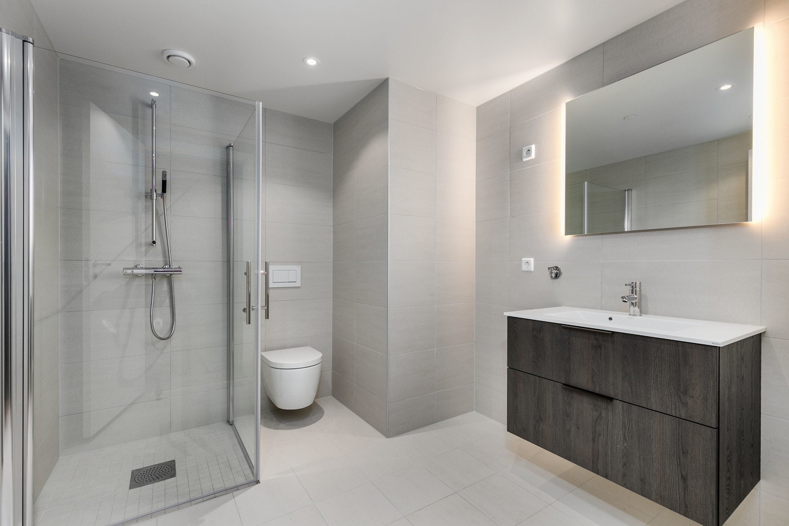 Delikat bad med flotte fliser på både vegger og gulv, downlights og gulvvarme. Lekker baderomsinnredning fra HTH av type Mood. Galleribilde