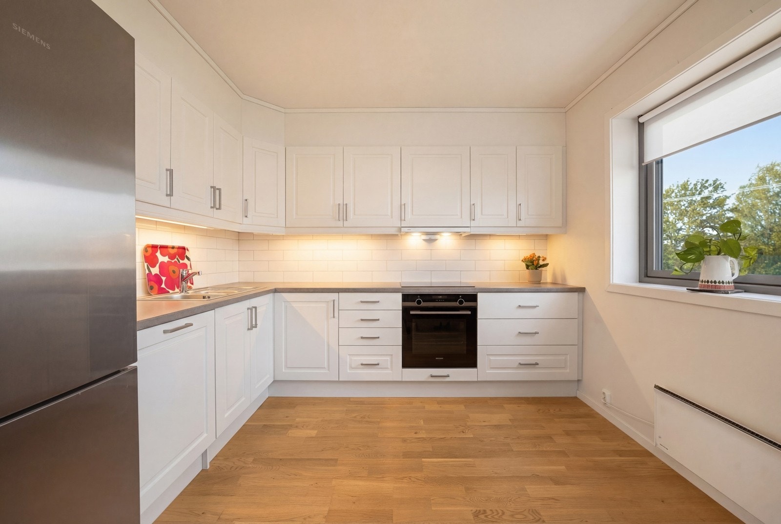 Moderne kjøkken med glatte fronter og integrerte hvitevarer. Galleribilde