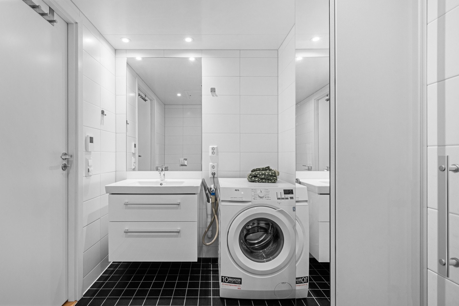 Badet har en dusjnisje og opplegg til vaskemaskin. Galleribilde