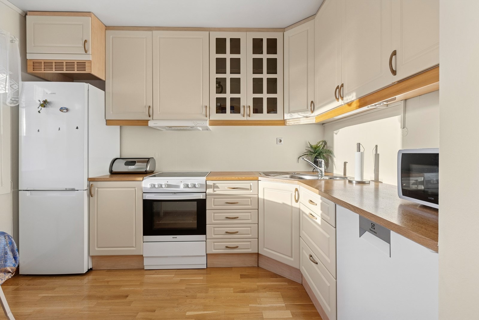 Trivelig hjørnekjøkken med lyse profilerte fronter. Galleribilde