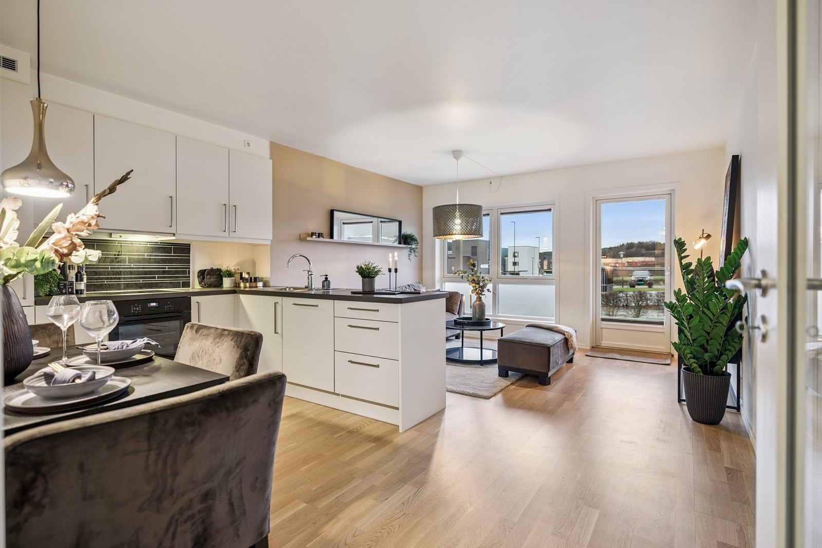 Den åpne løsningen mellom stue og kjøkken skaper en lys og sosial atmosfære. Galleribilde