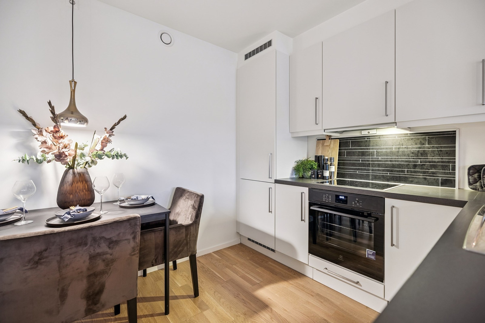 Kjøkkenet har en stilren innredning med integrerte hvitevarer fra byggeåret. Galleribilde