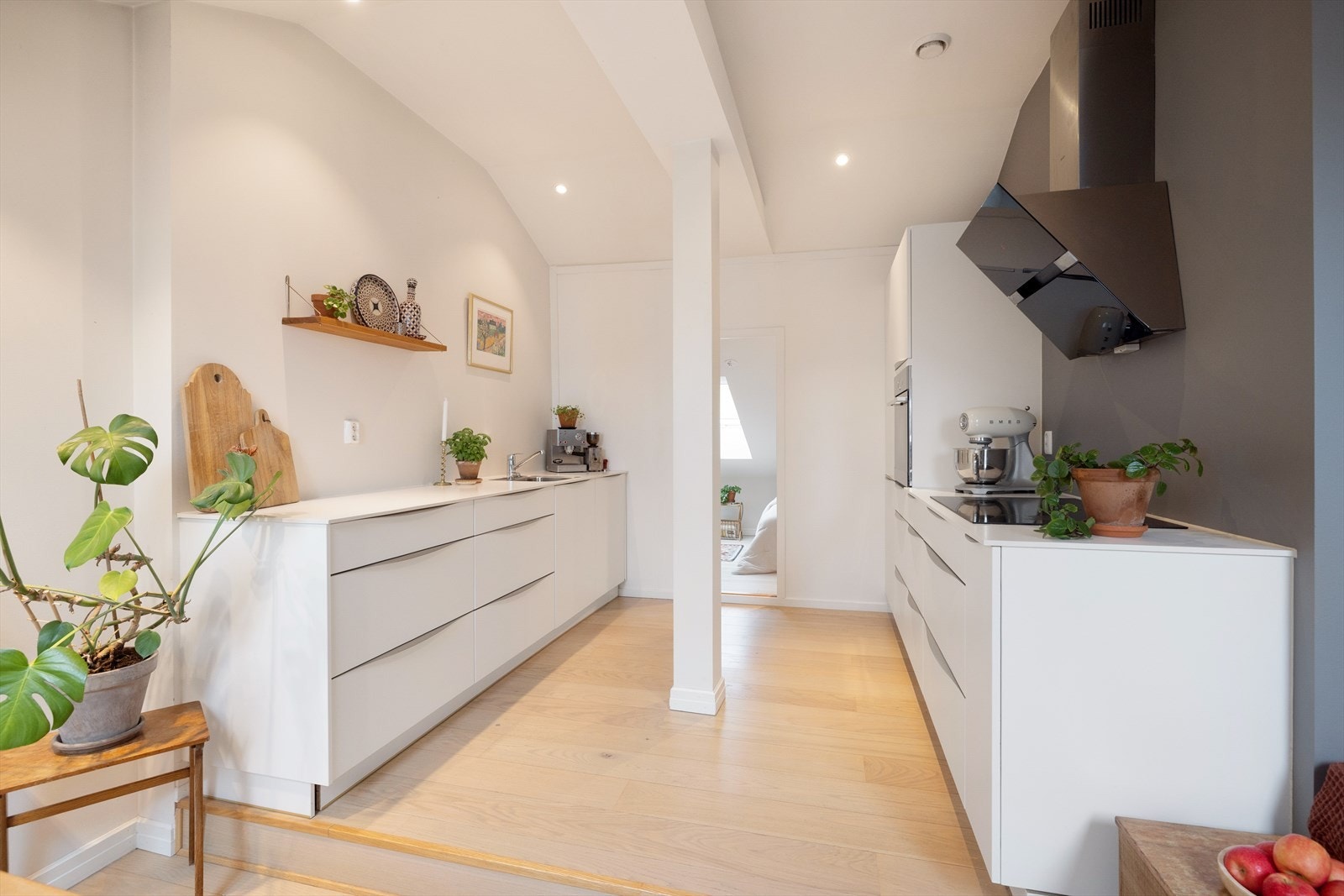 Kjøkkeninnredning med hvite glatte fronter og benkeplate i laminat. Galleribilde