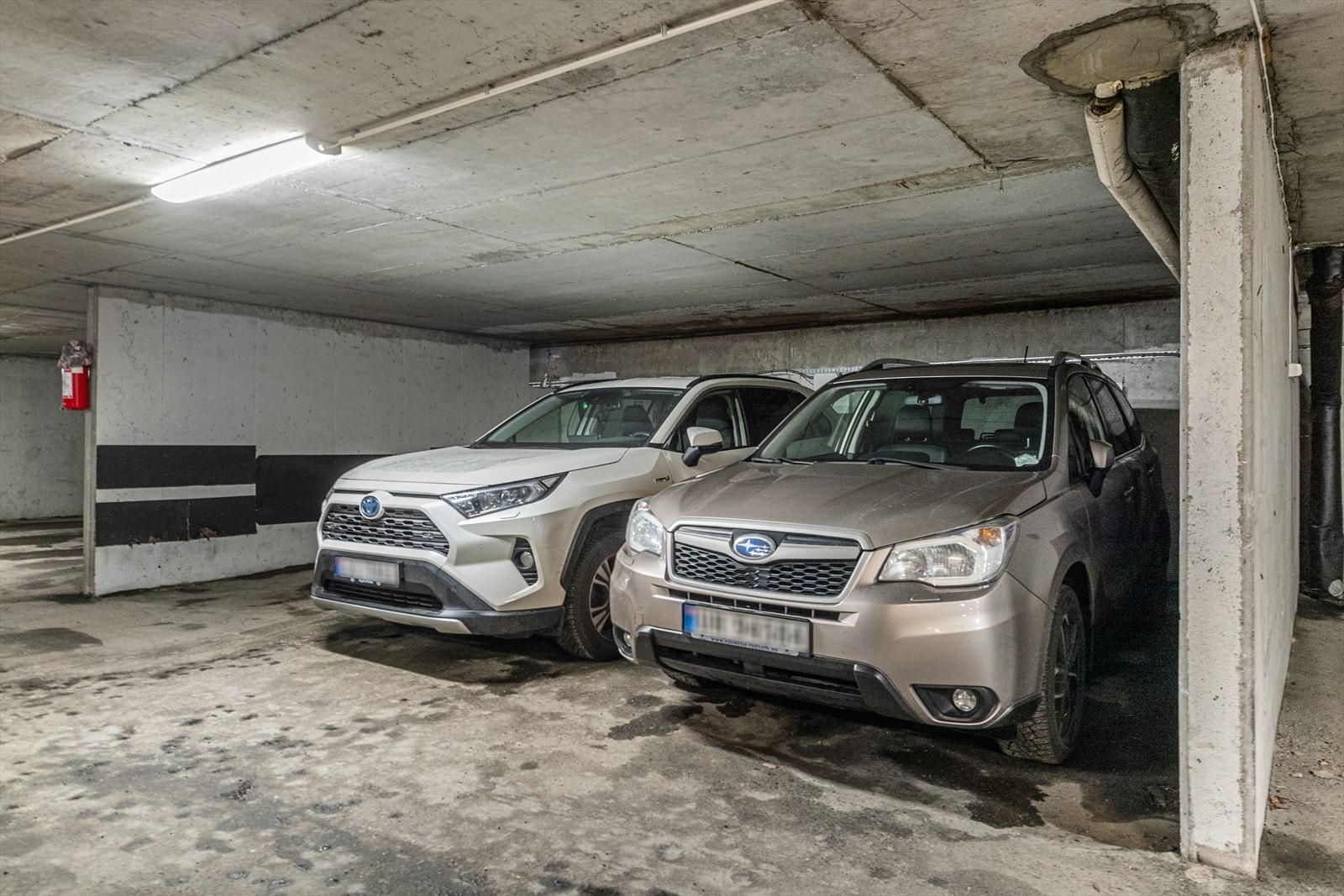 En parkeringsplass i garasje med betonggulv og god belysning. Galleribilde