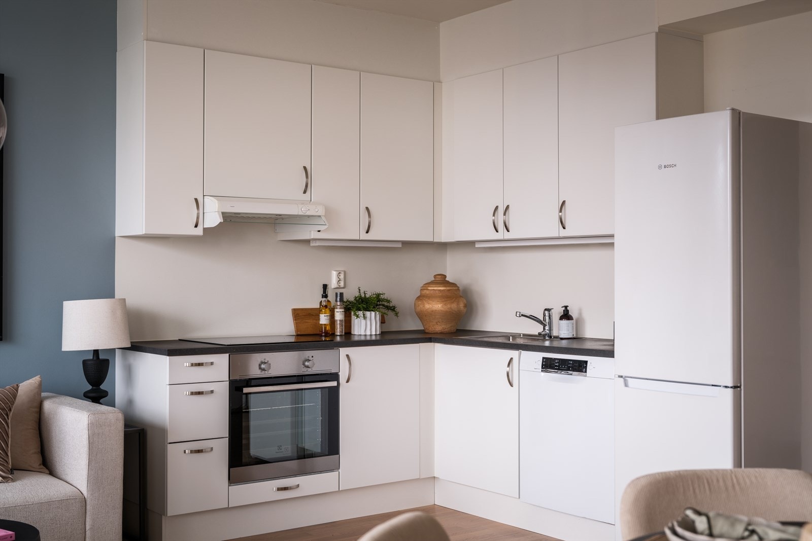 Kjøkkenet er utstyrt med integrerte hvitevarer som stekeovn, platetopp og oppvaskmaskin, samt plass til frittstående kjøleskap Galleribilde