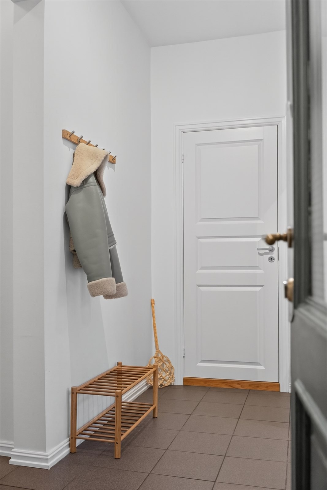 Lys entrè med plass til å henge fra seg yttertøy og plassere sine sko. Galleribilde