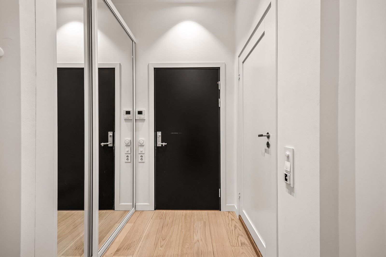 Romslig entré praktisk oppbevaring i skyvedørsgarderobe med speildører Galleribilde