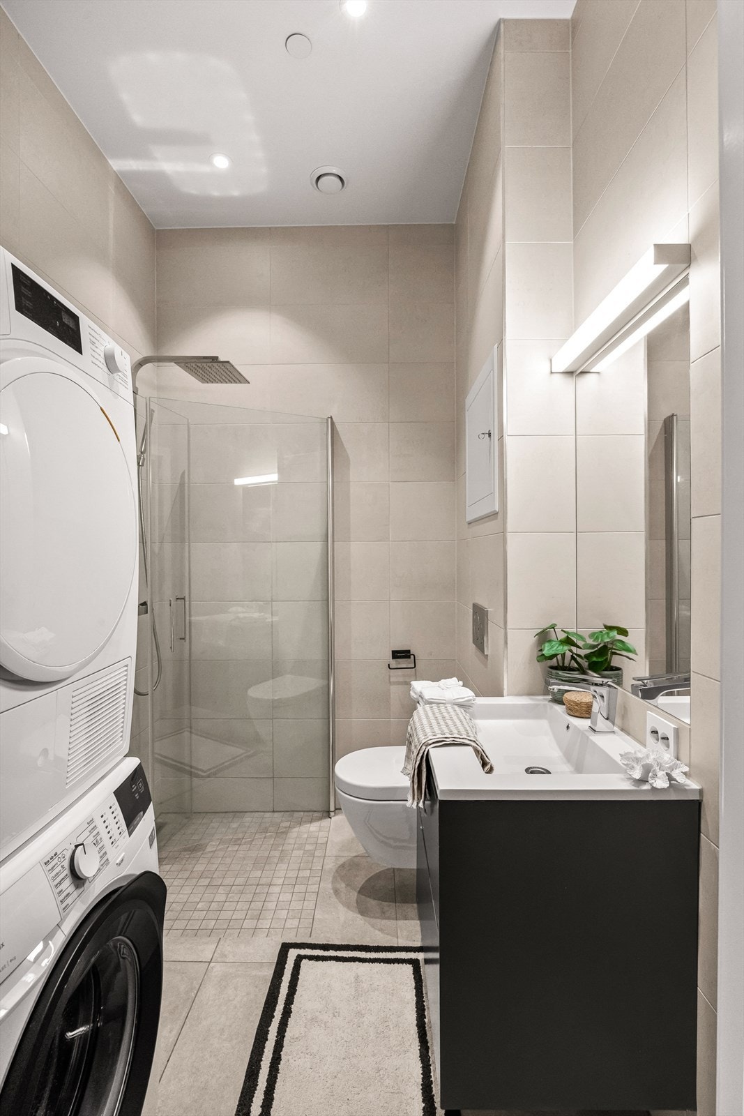 Lekkert flislagt bad med gulvvarme og downlights Galleribilde