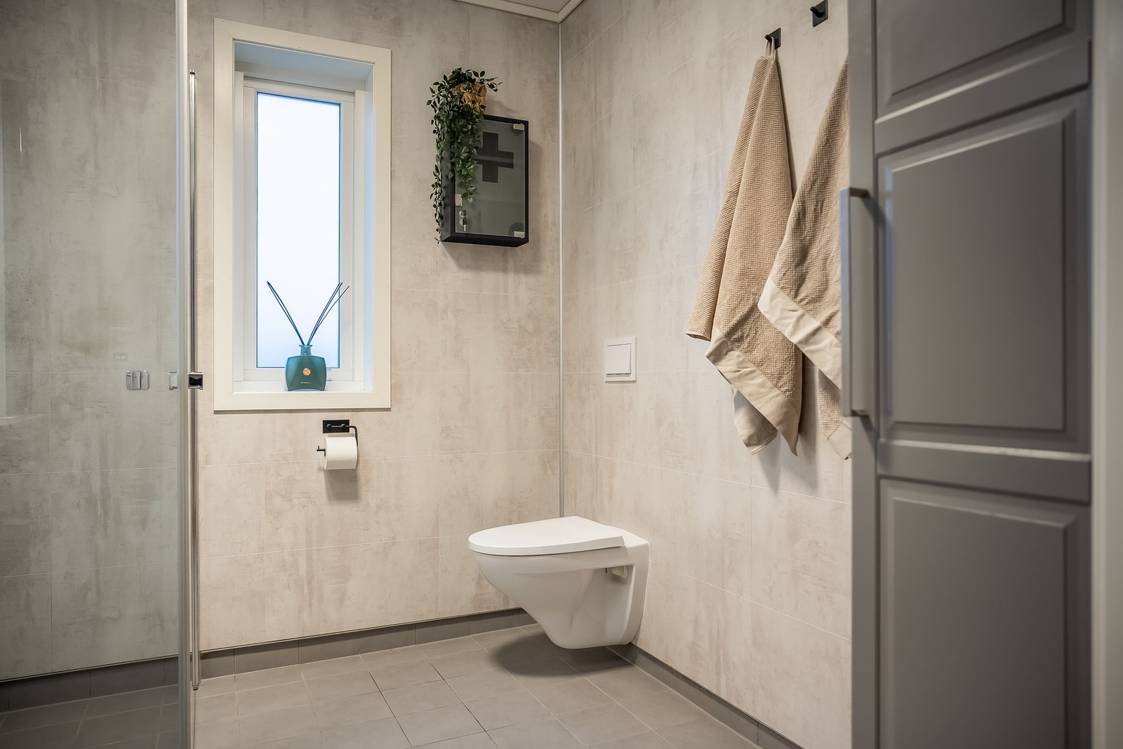 Badet har innredning med servant, høyskap, speil, dusj og toalett. Galleribilde