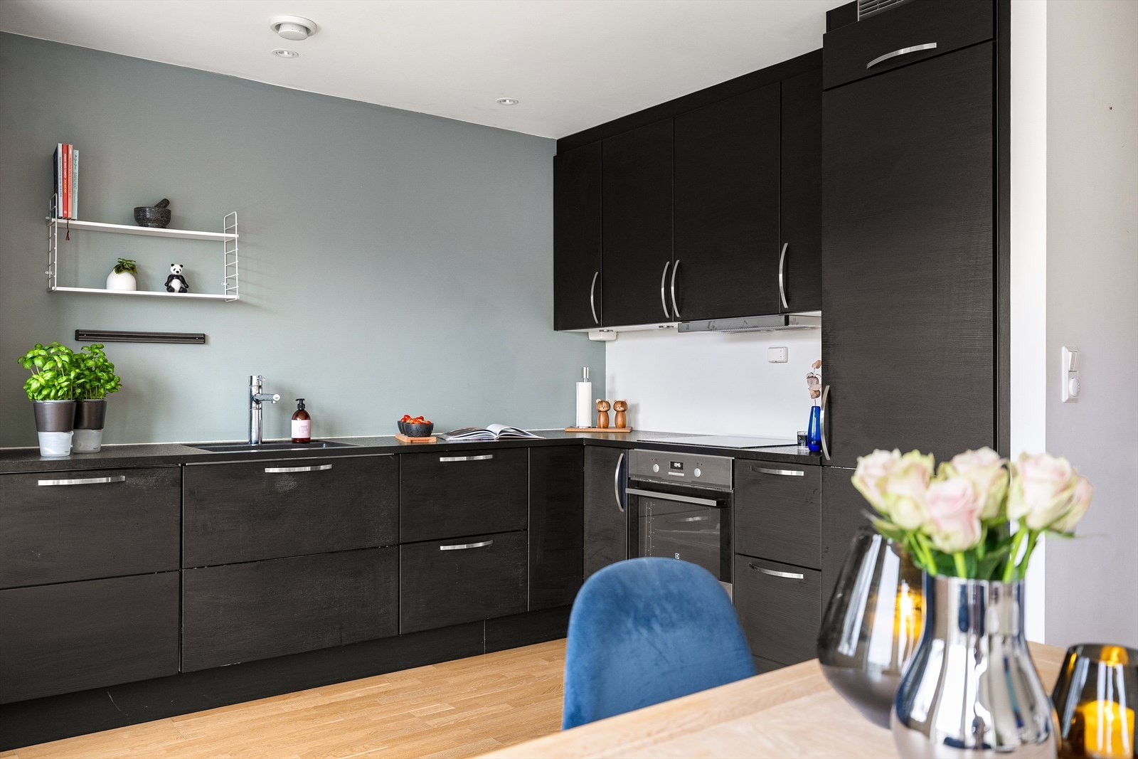 Kjøkkenet har sort innredning med glatte fronter. Det er integrerte hvitevarer som kjøleskap, oppvaskmaskin, induksjonstopp og stekeovn. Galleribilde