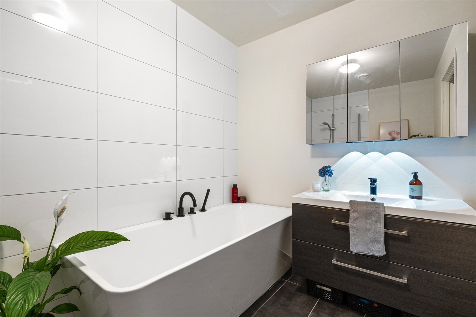 Moderne bad med vannbåten varme og fliser på gulv. Galleribilde