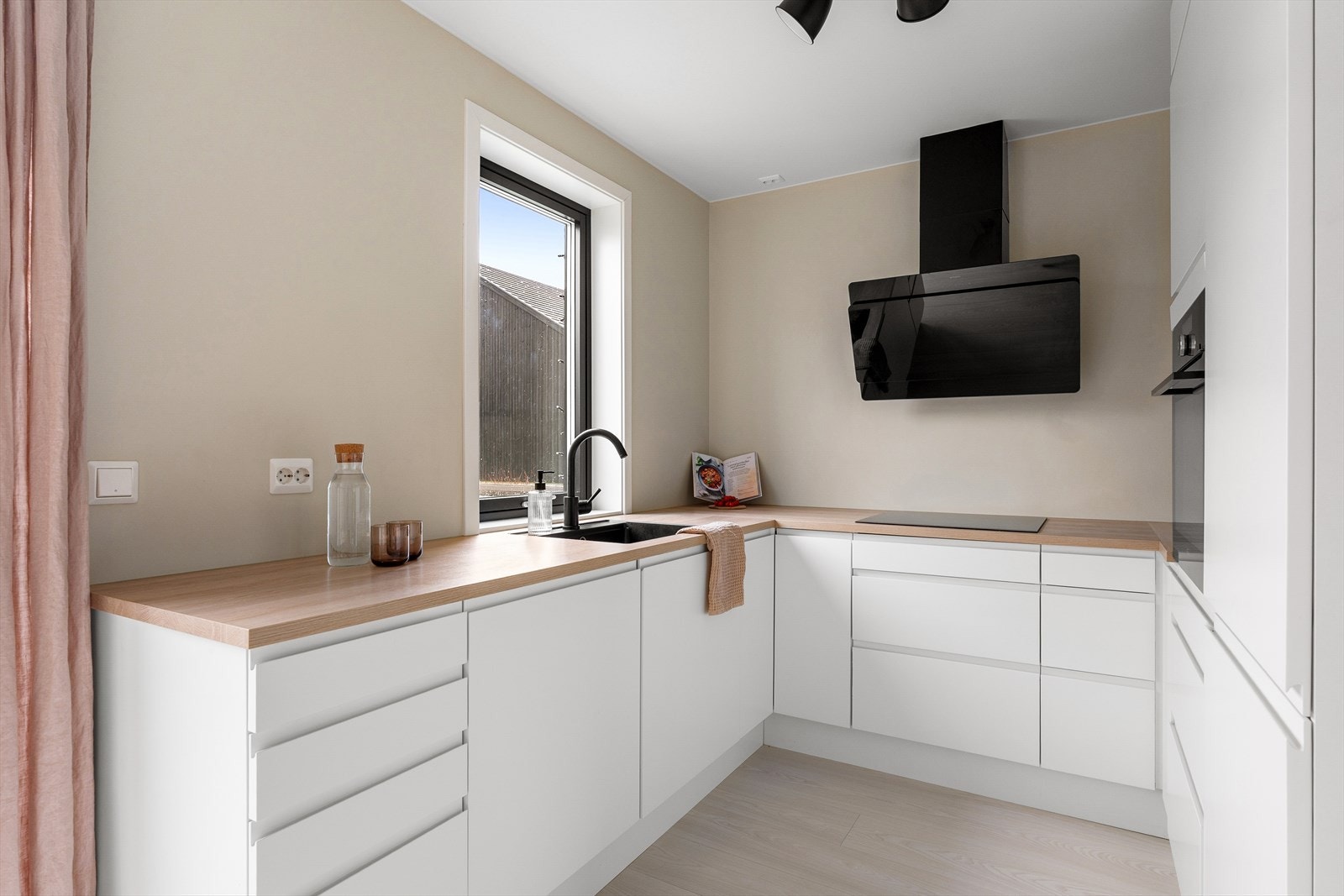 Pent kjøkken i klassisk hvit utførelse med laminert benkeplate. Galleribilde