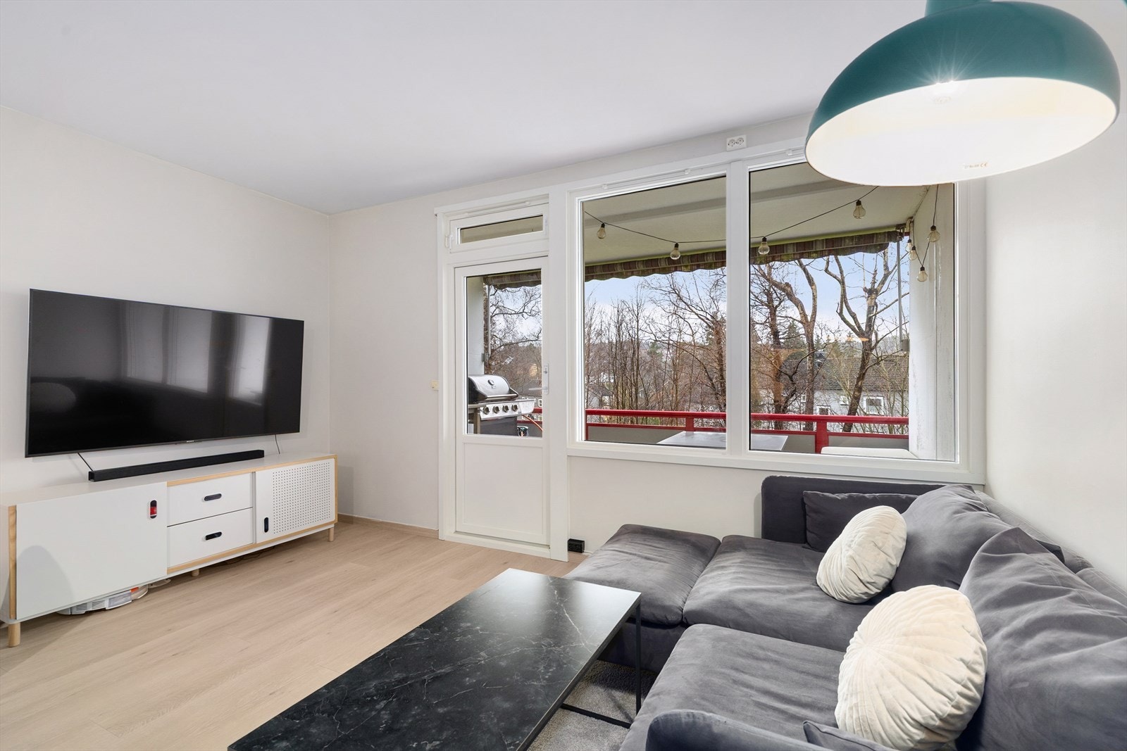 Lys og romslig stue med store vindusflater og utgang til en deilig overbygget balkong. Galleribilde