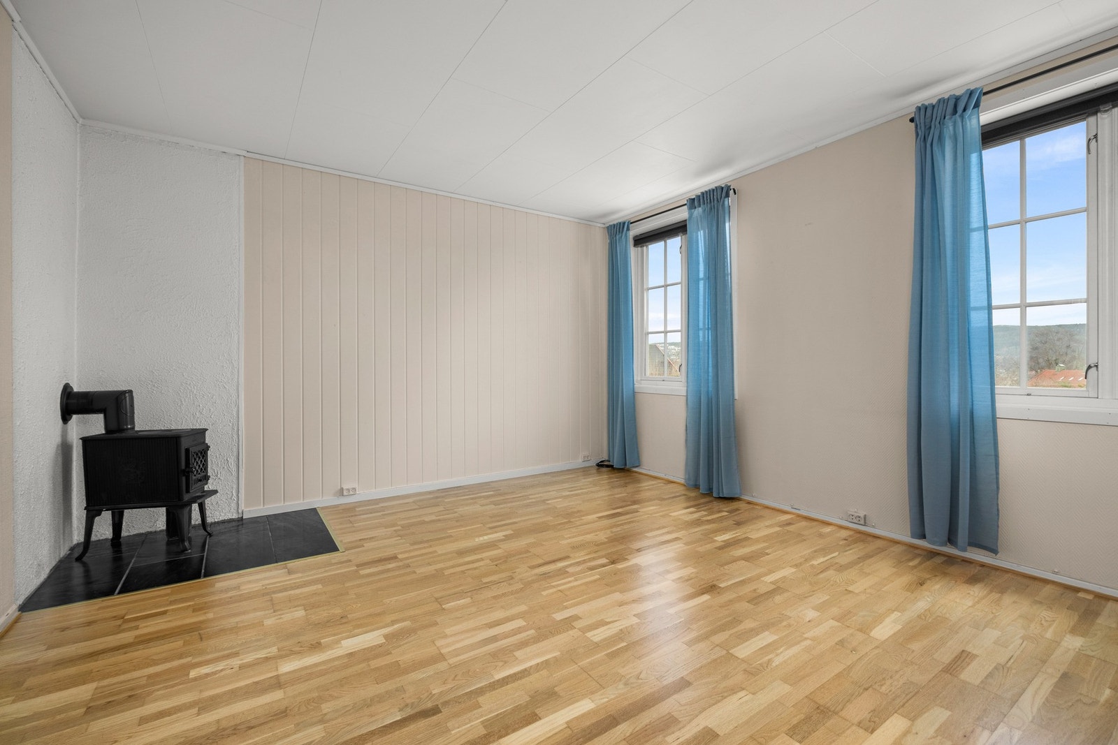 Stue i 1.etasje på 16,5 kvm. Dagens eier har leid ut 1.etasje og selv bodd i 2.etasje.Vedovn. Galleribilde