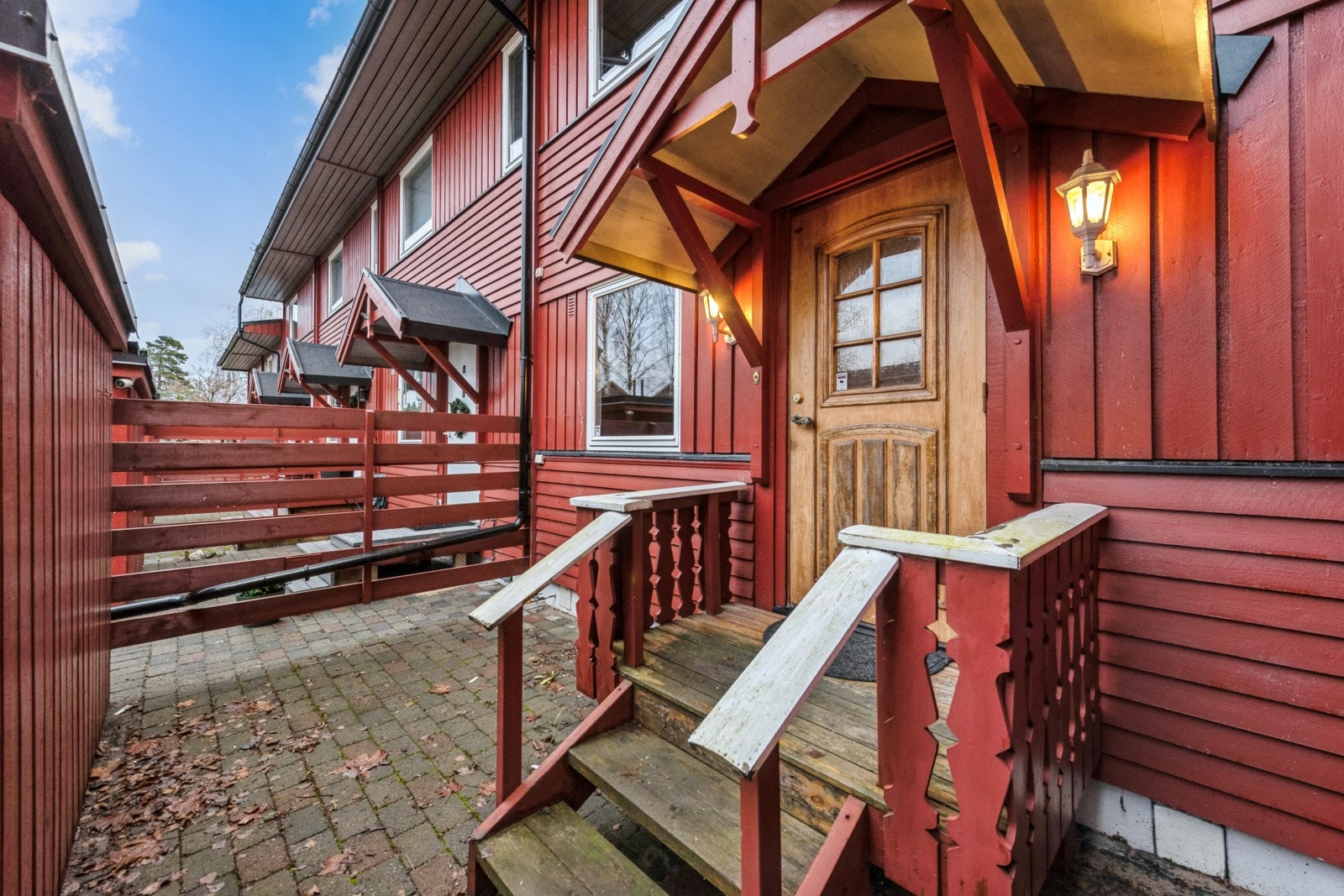 Et koselig inngangsparti med hellelagt uteplass foran kjøkkenvinduet. Galleribilde