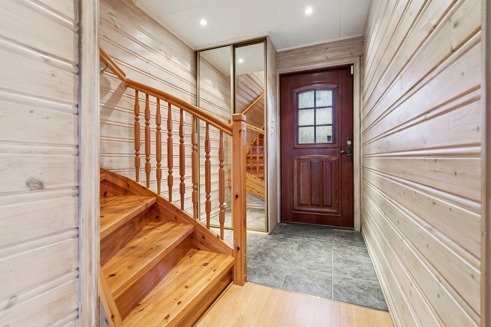Lys og åpent vindfang, hyggelig til å ønske venner og familie velkommen. Trapperom med skyvedørsgarderobe med speil i front. Galleribilde