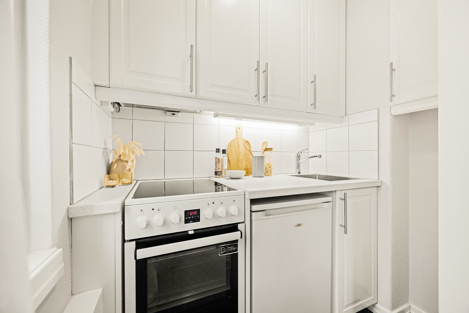 Kjøkkenet er praktisk utstyrt med nedsenket oppvaskkum i metall og ett-greps armatur, samt flislagt bakvegg mellom overskap og underskap. Galleribilde