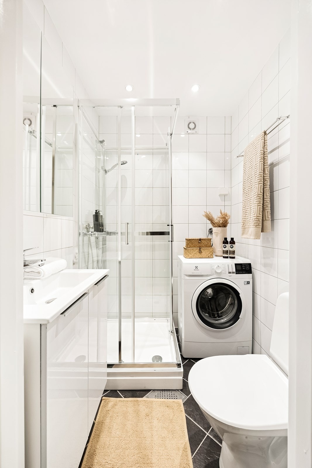 Tidløst bad fra 2012 med flislagt gulv og varmekabler i gulvet. Flislagte vegger og nedsenket himling med downlights. Galleribilde