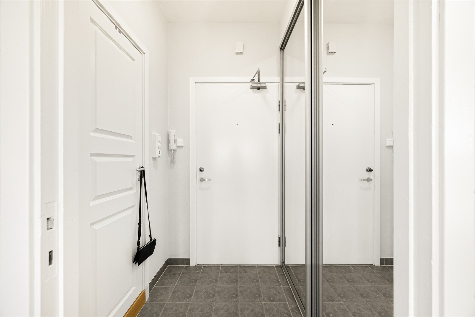 Lys og innbydende entré med god plass til å henge av seg yttertøy og sko i medfølgende skyvedørsgarderobe. Dørcalling. Galleribilde