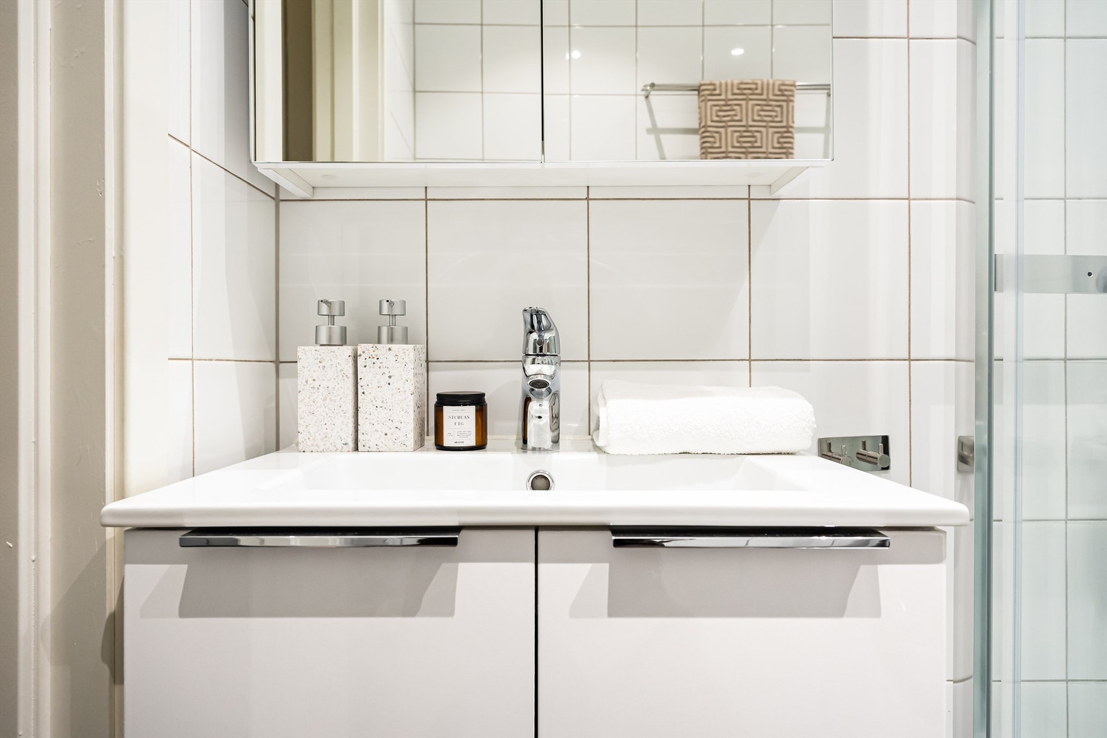 Vegghengt servantinnredning med nye dører (2024) og ett-greps armatur. Vegghengt speilskap (2024). Galleribilde