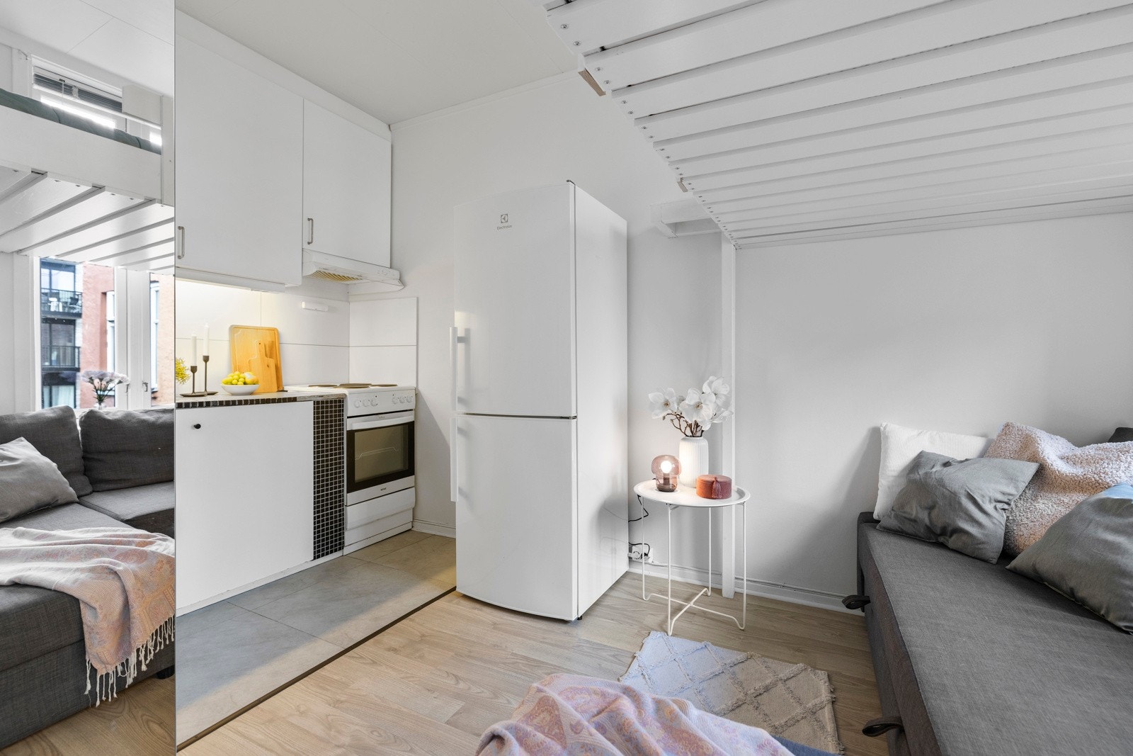 Kjøkkenet har en plassbesparende og funksjonell utforming, med glatt laminert innredning i hvit utførelse. Galleribilde