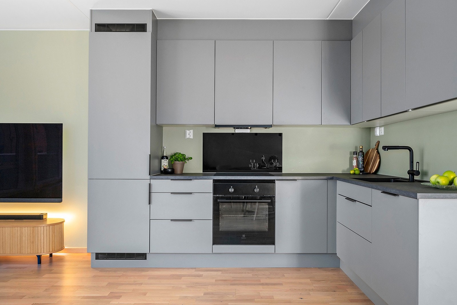 Delikat kjøkken fra HTH, med fronter i sort farge og faset kant. Laminat benkeplate med planlimt komposittkum. Galleribilde