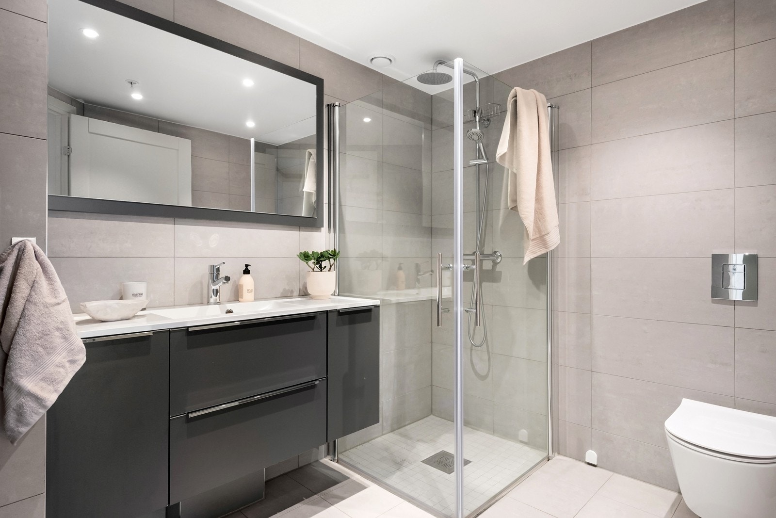 Flislagt baderom med gulvvarme og plass til vaskemaskin/tørketrommel i egen nisje. Galleribilde